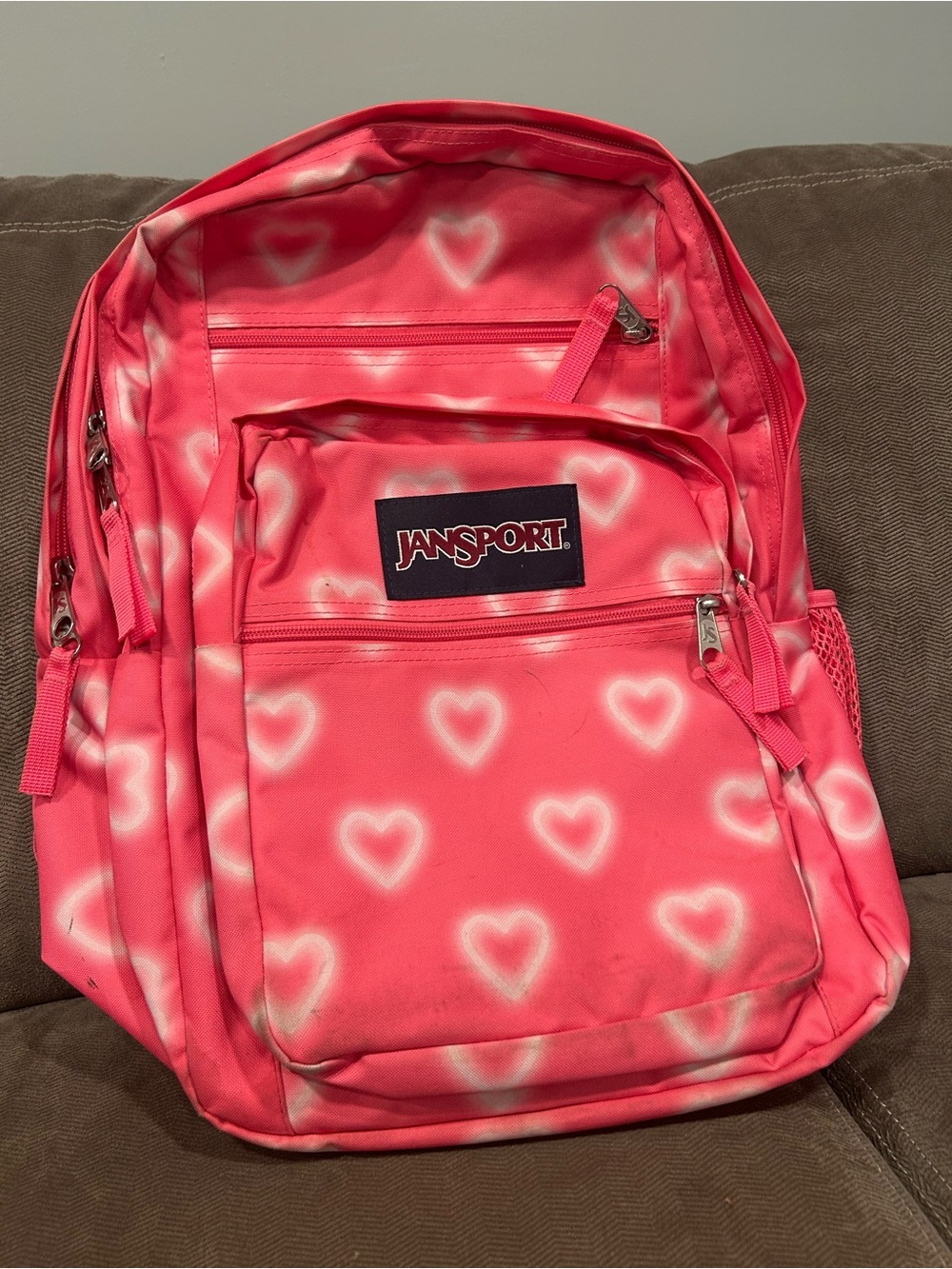 JanSport backpack in the "Happy Hearts Pink" pattern.